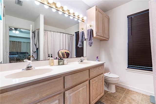 705 Aurora St, Bishop, TX 78343 - full bath featuring toilet, double vanity, tile patterned floors, baseboards, and ceiling fan