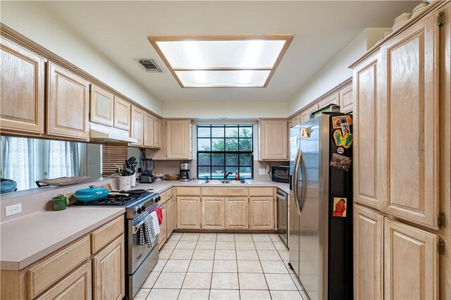 705 Aurora St, Bishop, TX 78343 - kitchen with stainless steel appliances, light brown cabinets, under cabinet range hood, light tile patterned flooring, and light countertops