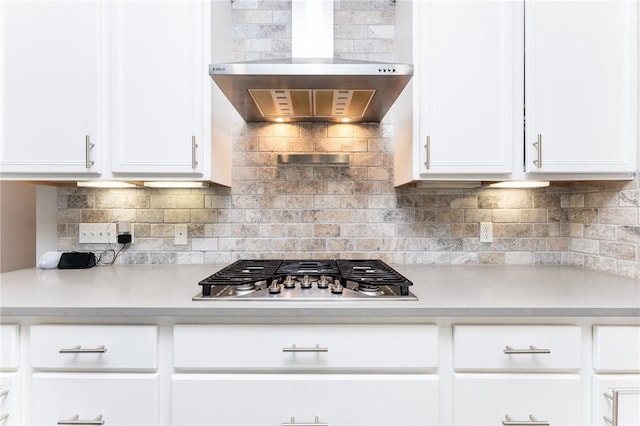 8233 Yosemite Dr, Corpus Christi, TX 78414 - kitchen featuring wall chimney range hood, stainless steel gas stovetop, light countertops, and white cabinets