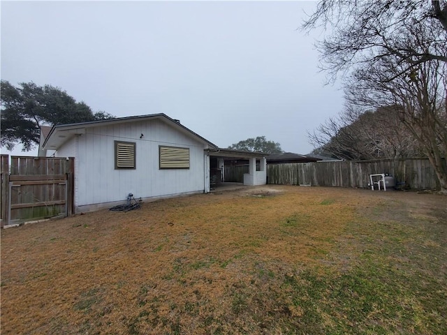 rear view of house with a lawn and fence