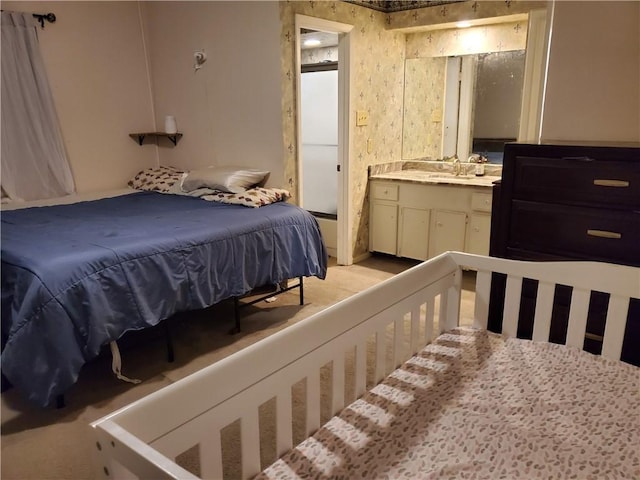 bedroom featuring ensuite bathroom and sink