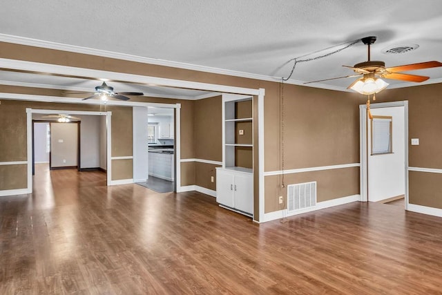 unfurnished living room featuring wood-type flooring, a textured ceiling, ceiling fan, and crown molding