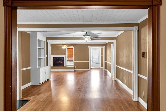 unfurnished living room with wood ceiling, ceiling fan, light hardwood / wood-style floors, and ornamental molding