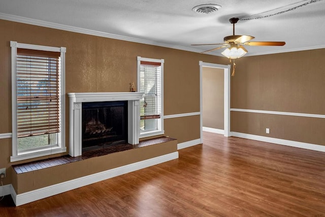 unfurnished living room featuring ceiling fan, wood-type flooring, and ornamental molding