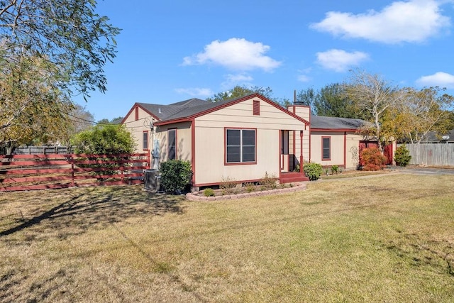 view of front of property with a front yard and central AC unit