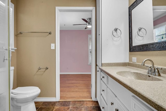 bathroom featuring ornamental molding, vanity, ceiling fan, hardwood / wood-style flooring, and toilet