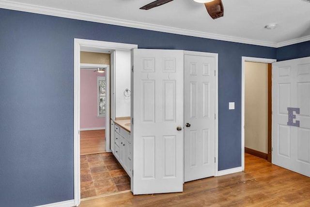 unfurnished bedroom featuring ceiling fan, ornamental molding, and light wood-type flooring