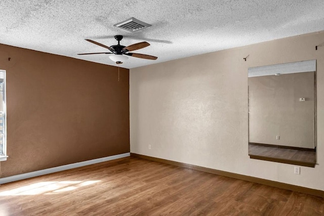 spare room featuring ceiling fan, wood-type flooring, and a textured ceiling