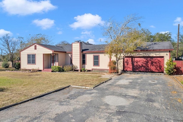 single story home with a garage and a front lawn