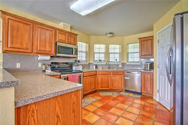 9386 Private Rd Unit 2155, Sinton, TX 78387 - kitchen with appliances with stainless steel finishes, tasteful backsplash, and brown cabinetry