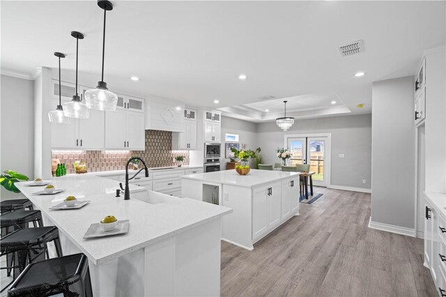 7721 Keiras Way, Corpus Christi, TX 78414 - kitchen with a sink, a center island, decorative backsplash, oven, and baseboards