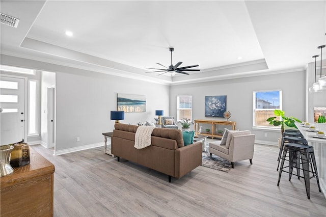 7721 Keiras Way, Corpus Christi, TX 78414 - living area with a raised ceiling, a ceiling fan, baseboards, light wood-style flooring, and crown molding