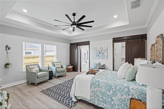 7721 Keiras Way, Corpus Christi, TX 78414 - bedroom featuring a barn door, a raised ceiling, light wood finished floors, recessed lighting, and crown molding