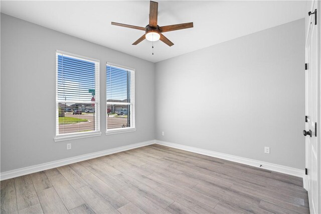 7721 Keiras Way, Corpus Christi, TX 78414 - empty room featuring ceiling fan, wood finished floors, baseboards, and a barn door