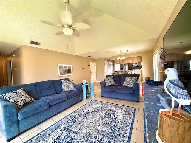 living area featuring lofted ceiling, light tile patterned floors, visible vents, and a textured ceiling