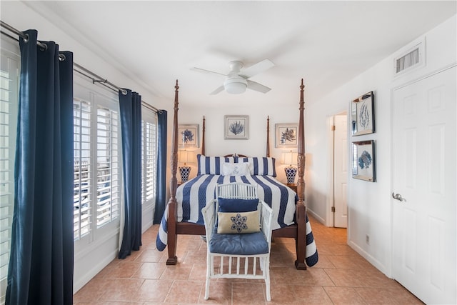 tiled bedroom with multiple windows and ceiling fan