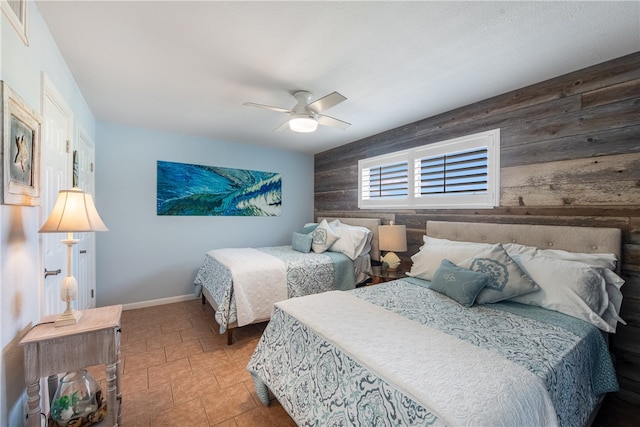 tiled bedroom featuring ceiling fan and wooden walls