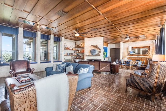 living room with ceiling fan, wood ceiling, and brick wall