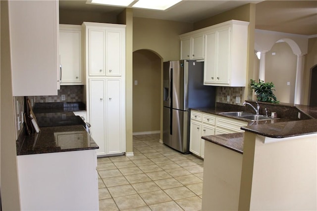 kitchen with tasteful backsplash, kitchen peninsula, and white cabinetry