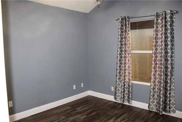 empty room with hardwood / wood-style floors and vaulted ceiling