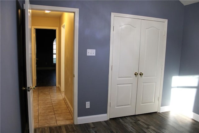 unfurnished bedroom featuring dark hardwood / wood-style floors and a closet