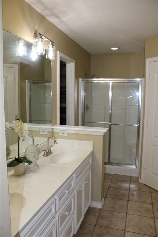 bathroom featuring tile patterned floors, a shower with door, and vanity