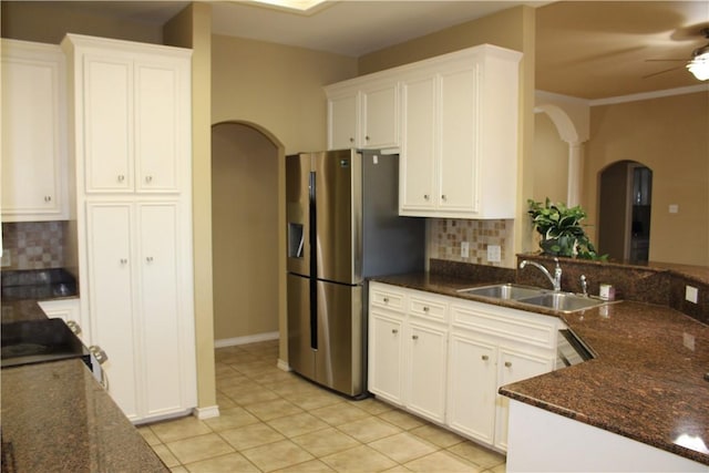 kitchen featuring white cabinetry, sink, tasteful backsplash, dark stone counters, and light tile patterned floors