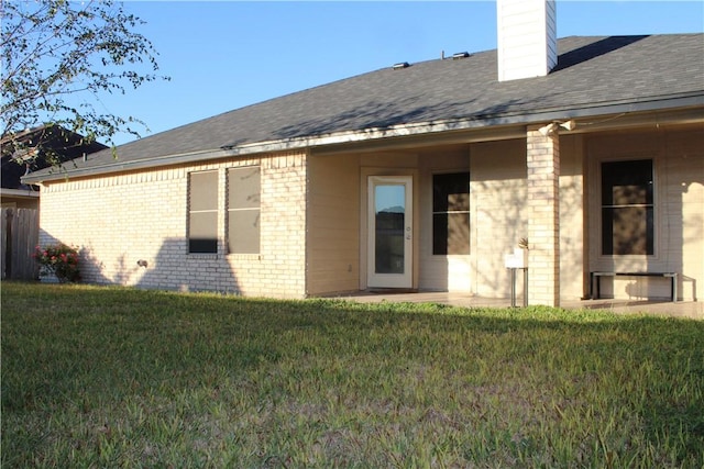 rear view of house with a lawn and a patio