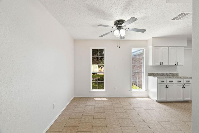 1134 Harbor Village Dr, Corpus Christi, TX 78412 - kitchen featuring a textured ceiling, white cabinetry, ceiling fan, and baseboards