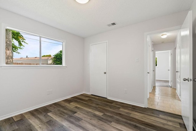 1134 Harbor Village Dr, Corpus Christi, TX 78412 - unfurnished bedroom featuring a textured ceiling, wood finished floors, and baseboards