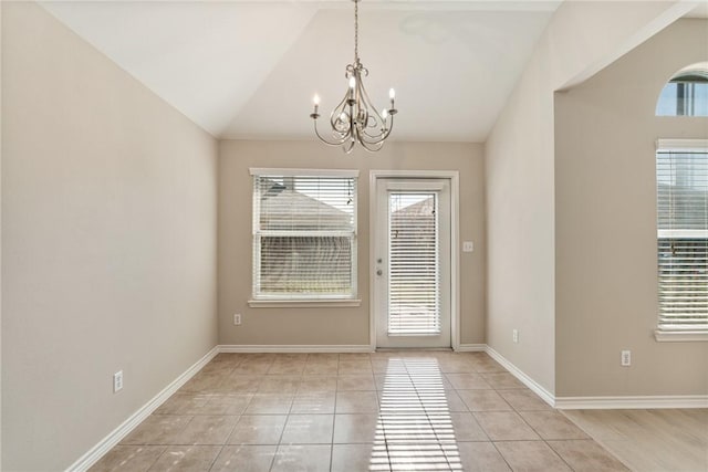 doorway with a healthy amount of sunlight, an inviting chandelier, light tile patterned floors, and lofted ceiling