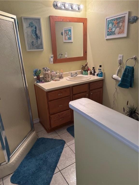 bathroom with tile patterned floors, vanity, and a shower stall