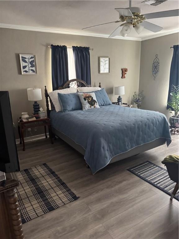 bedroom featuring a ceiling fan, wood finished floors, and ornamental molding