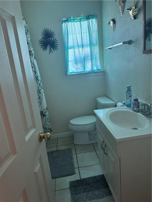 bathroom featuring tile patterned flooring, toilet, vanity, and baseboards