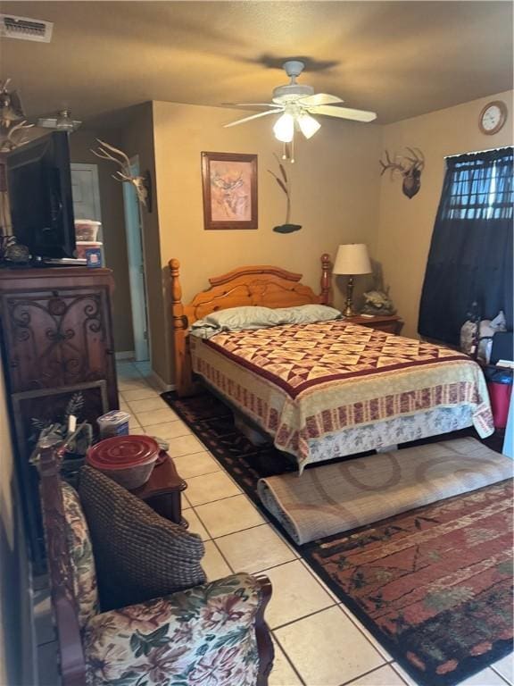 bedroom featuring light tile patterned flooring, visible vents, and a ceiling fan