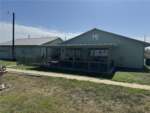 back of property featuring central AC, a yard, and fence