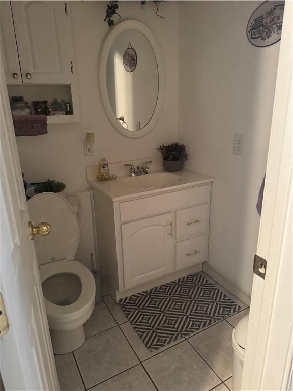 half bath with vanity, tile patterned floors, and toilet