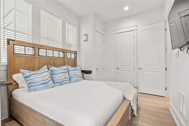 bedroom featuring light wood finished floors, multiple windows, visible vents, and recessed lighting