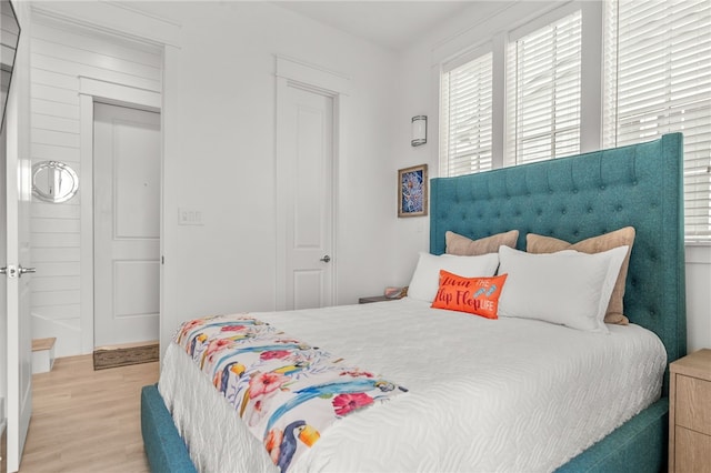 bedroom featuring multiple windows and light wood finished floors