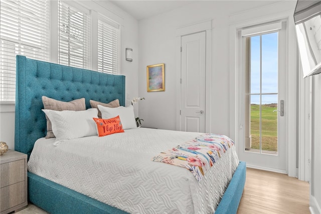 bedroom featuring access to exterior and wood finished floors