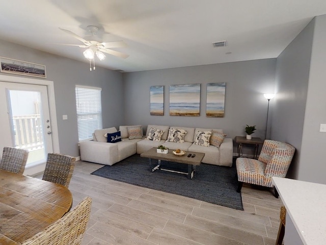 living room with light wood-type flooring and ceiling fan