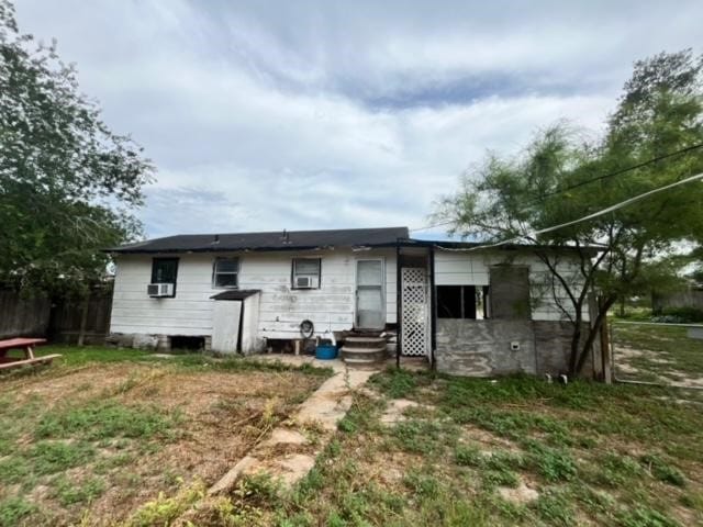 rear view of house with a lawn and cooling unit