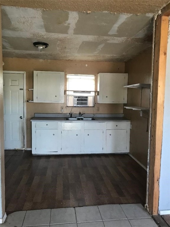 kitchen featuring tile patterned floors, white cabinetry, and sink