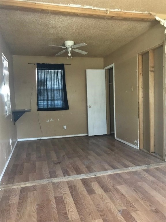 interior space with wood-type flooring, a textured ceiling, and ceiling fan