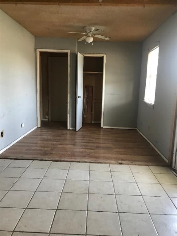 unfurnished bedroom with ceiling fan and light tile patterned floors