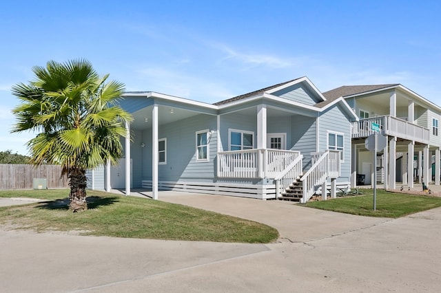 141 Barnacle Dr, Rockport, TX 78382 - view of front facade featuring a carport, a front lawn, a porch, and driveway