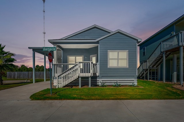 141 Barnacle Dr, Rockport, TX 78382 - view of front facade featuring an attached carport, stairway, driveway, a porch, and a front lawn