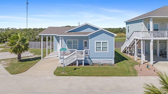 141 Barnacle Dr, Rockport, TX 78382 - view of front of house with a front yard, fence, a porch, stairs, and concrete driveway