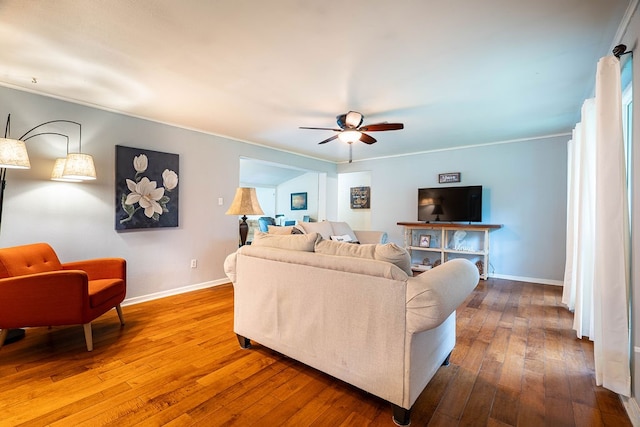 living room with hardwood / wood-style floors, ceiling fan, and crown molding