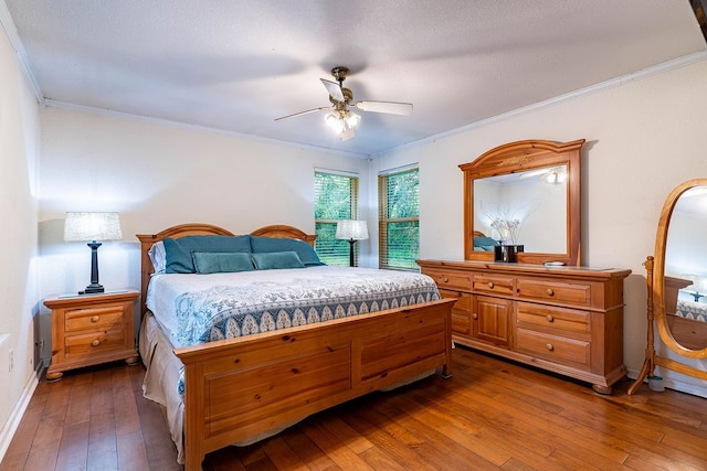 bedroom featuring dark hardwood / wood-style flooring, ornamental molding, and ceiling fan